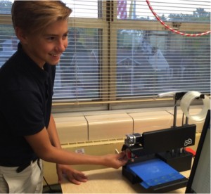 8th grade OLL Student Kaden Robison prepares to print using the 3D printer