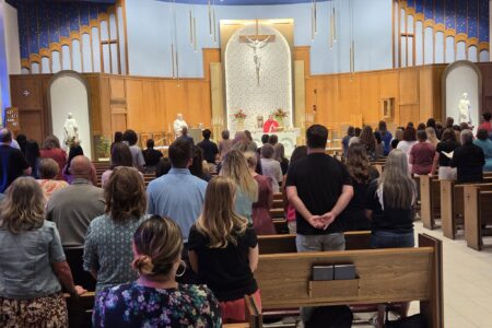 group facing toward altar in catholic church at mass